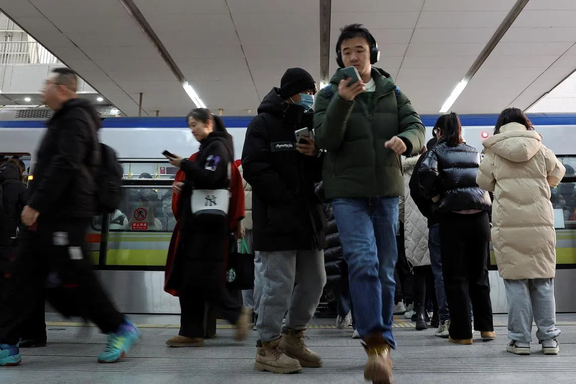 Commuters leave a train during morning rush hour at a subway station in Beijing.