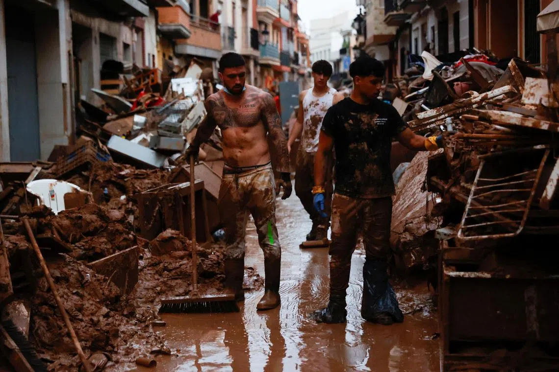 People help to clean, following heavy rains that caused floods, in Paiporta, near Valencia, Spain, on Nov 4, 2024. 