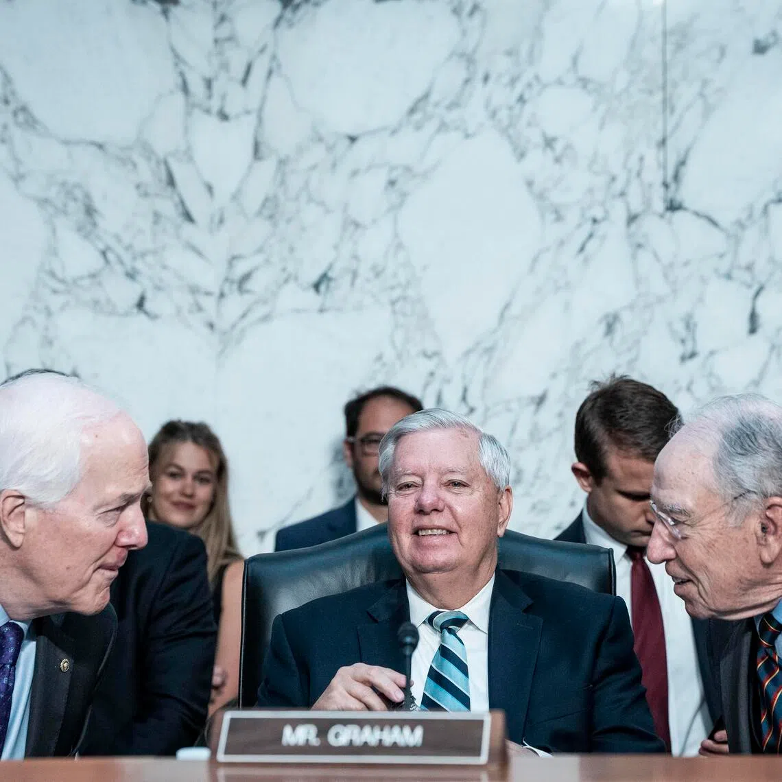(From left) Senators John Cornyn, Lindsey Graham and Chuck Grassley chatting as the Senate Judiciary Committee meets to advance federal court nominees on Capitol Hill, Washington, in 2025.
