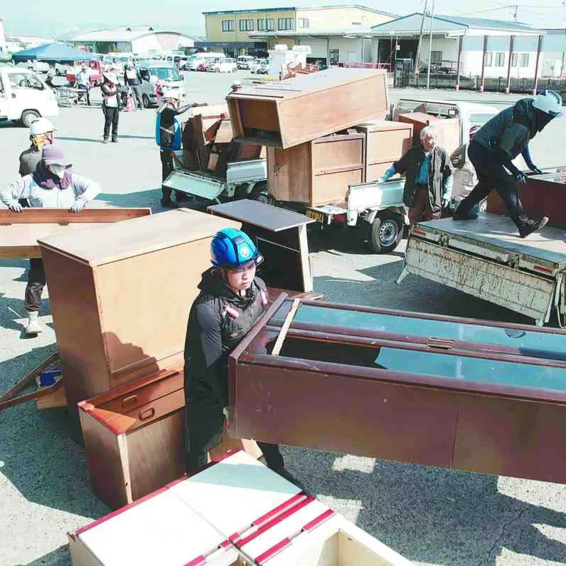 People bring disaster debris to a temporary collection site in Kumamoto prefecture.