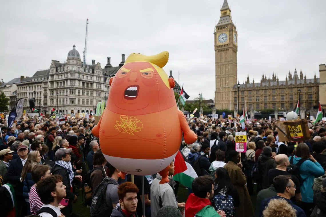 A "Baby Trump Blimp" balloon is held aloft during a Stop Trump Coalition protest in London on Sept 17, against the state visit to the UK by US President Donald Trump.
