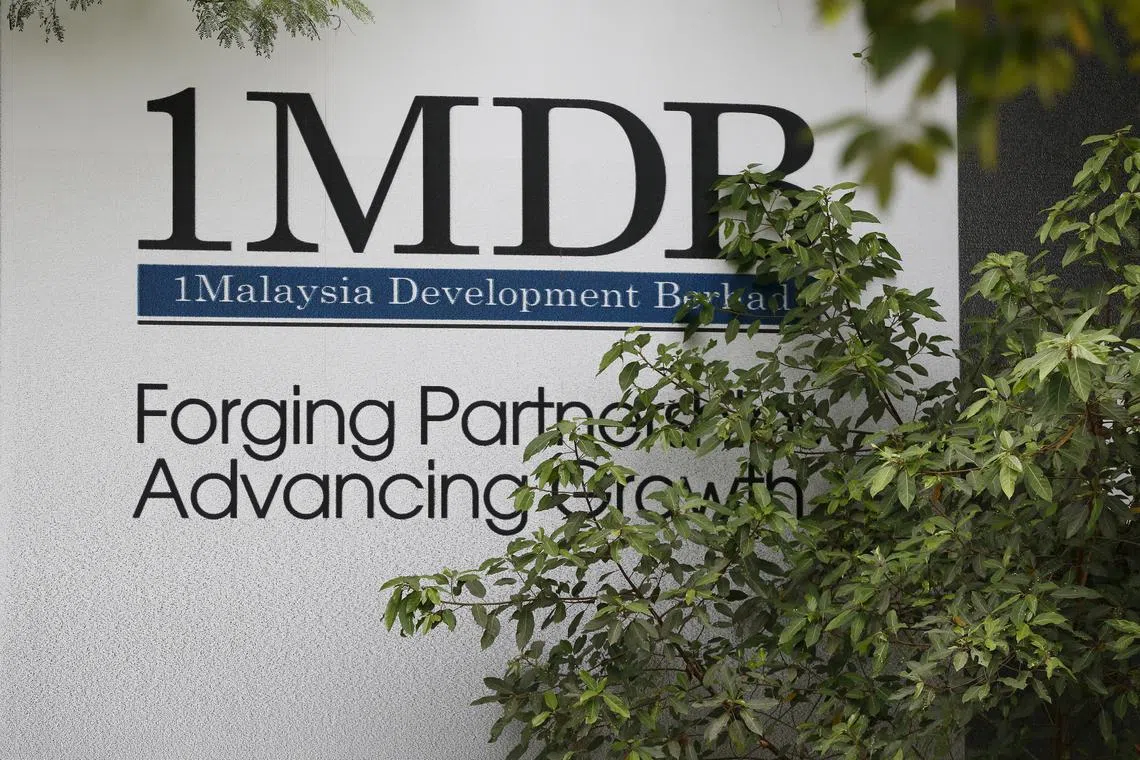FILE PHOTO: Foliage partly covers a 1 Malaysia Development Berhad (1MDB) billboard at the funds flagship Tun Razak Exchange development in Kuala Lumpur, Malaysia, July 3, 2015. REUTERS/Olivia Harris/File Photo
