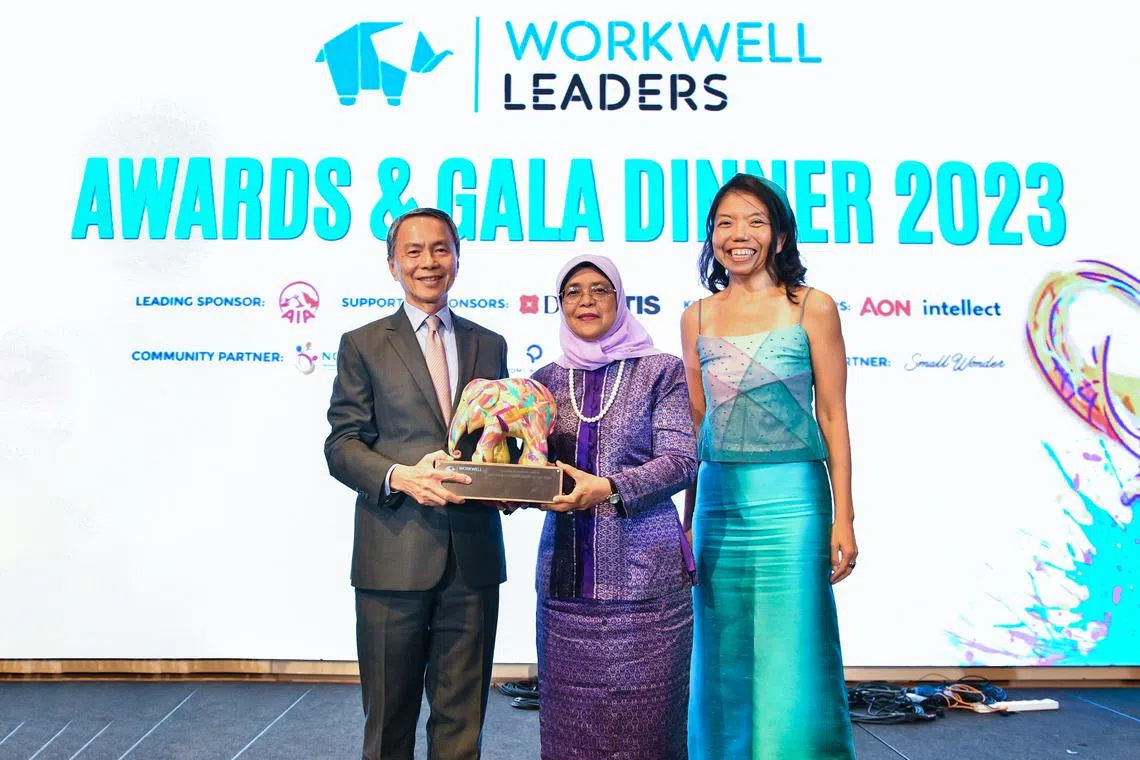 Mr Hsieh Fu Hua, chairman of the NUS Board of Trustees, receiving the overall Wellbeing Organisation of the Year Award from President Halimah Yacob and Ms Anthea Ong.