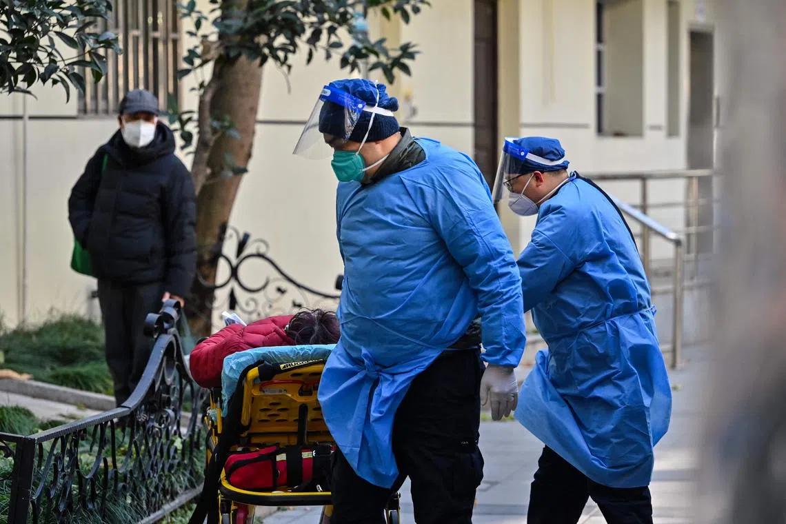 Staff in protective clothes transporting a patient at the fever clinic of a hospital in Shanghai on Dec 18, 2022.
