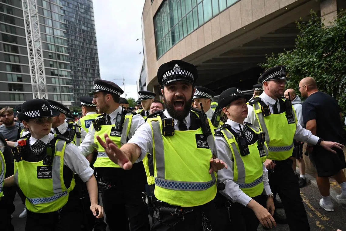 Police scuffling with protesters during a demonstration outside the Britannia Hotel in Canary Wharf in London on Aug 3, 2025 over it's use to house asylum seekers. 