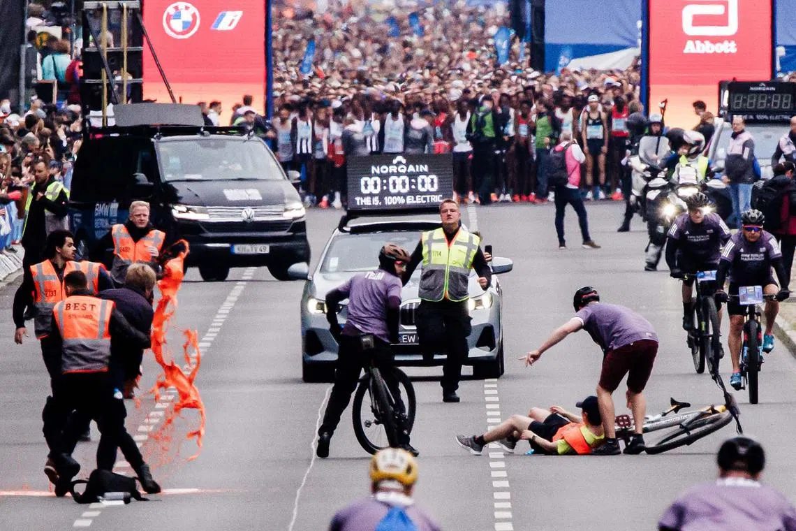 Climate activists of the 'Last Generation' group try to block the street ahead of the Berlin Marathon 2023, in Berlin, Germany, Sept 24.
