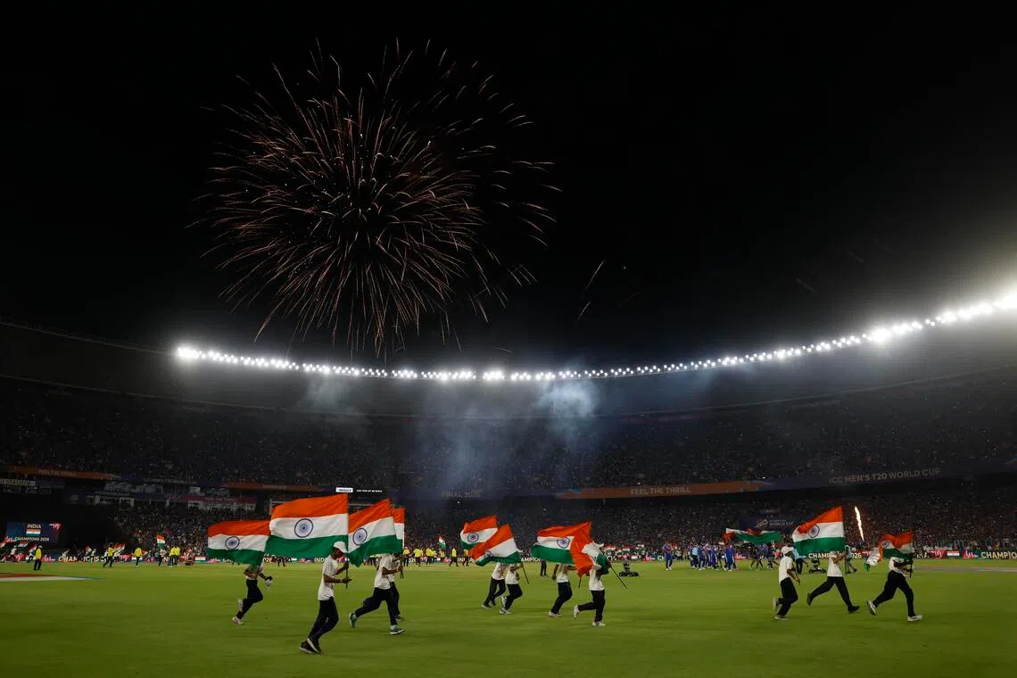 India flags are displayed on the Narendra Modi Stadium pitch as fans celebrate after the team won the cricket Men's T20 World Cup against New Zealand in Ahmedabad on March 8, 2026.