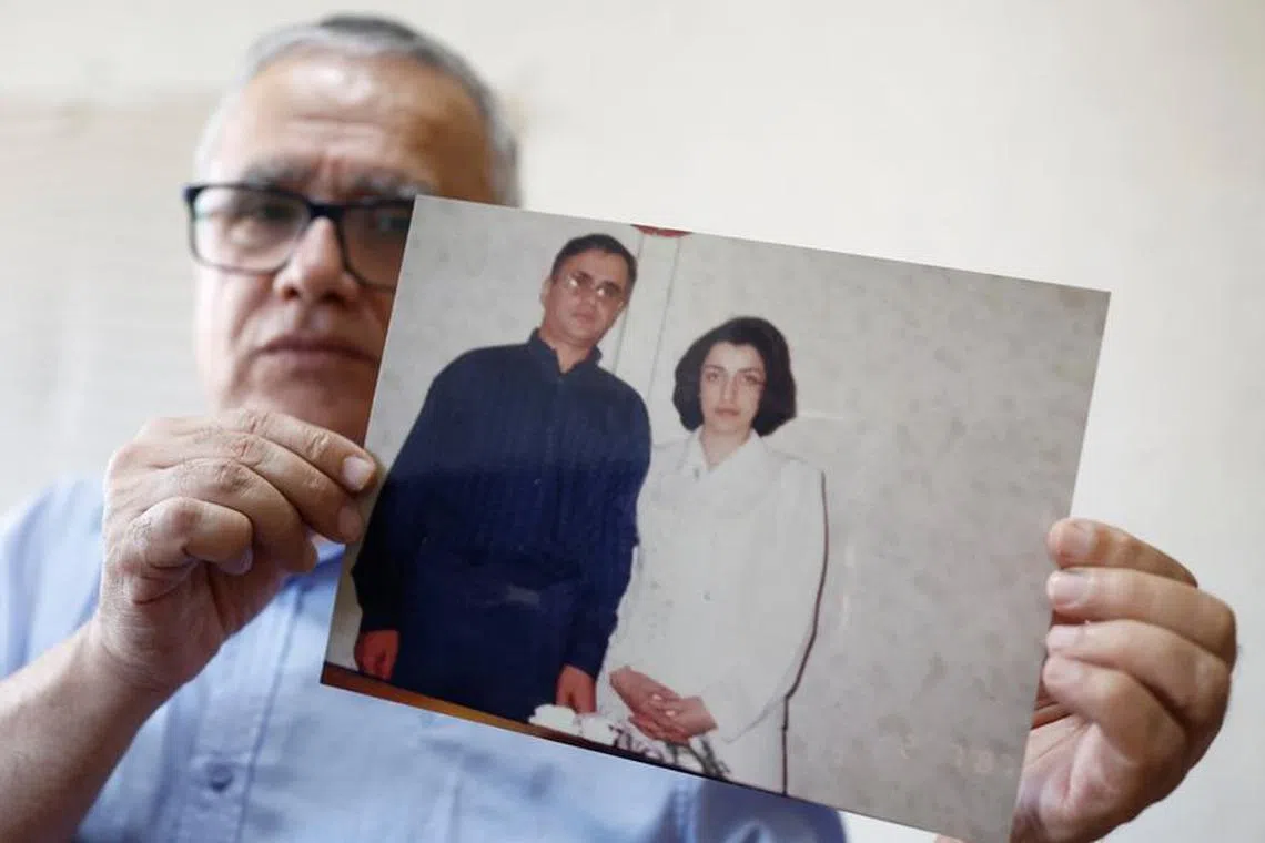 Taghi Ramahi, husband of Narges Mohammadi, a jailed Iranian women's rights advocate, who won the 2023 Nobel Peace Prize, poses with an undated photo of himself and his wife, during an interview at his home in Paris, France, October 6, 2023. REUTERS/Christian Hartmann