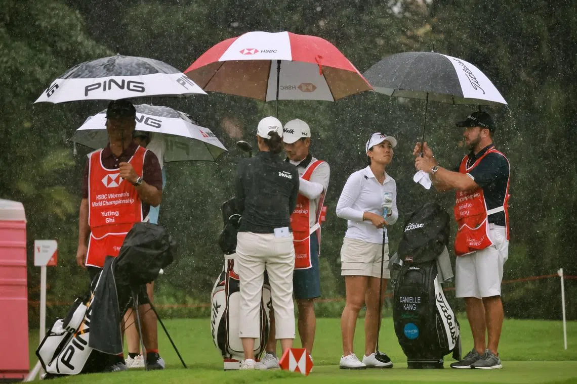 From right: Danielle Kang, Chella Choi and Shi Yuting (obscured) competing in the rain at the HSBC women’s world championship at Sentosa Golf Club on Friday.