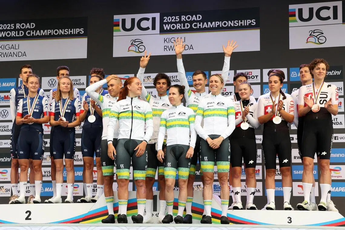 Team Australia celebrate on the podium after winning the team time trial mixed relay with second placed team France and third placed team Switzerland.