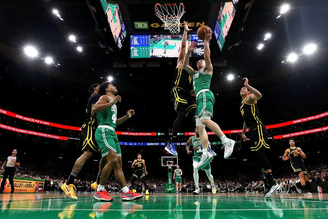 Payton Pritchard (No. 11) of the Boston Celtics taking a shot against Jerome Robinson (18) of the Golden State Warriors at TD Garden.