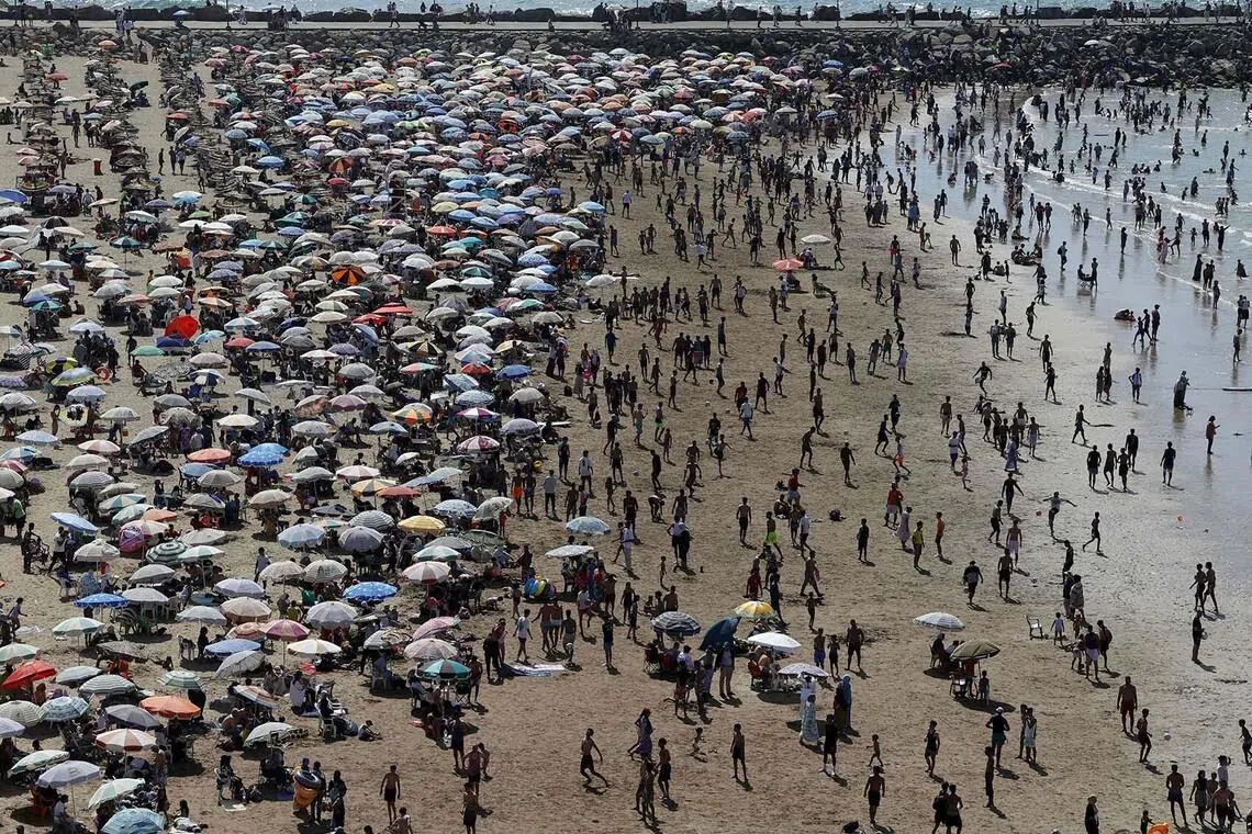 TOPSHOT - People visit the beach on a hot day in Rabat on June 28, 2026. (Photo by Abdel Majid BZIOUAT / AFP)