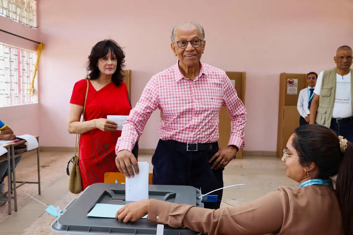 FILE PHOTO: Former Prime Minister of Mauritius and candidate for Alliance du Changement party Navin Ramgoolam casts his ballot as his wife Veena Ramgoolam stands beside, at a polling centre during the Mauritian general election in Vacoas/Floreal, Mauritius November 10, 2024. REUTERS/Ally Soobye/File Photo