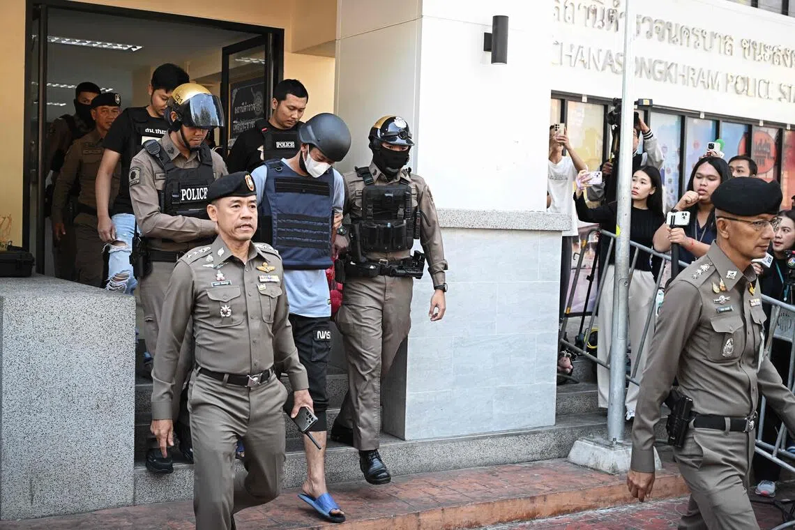 Thai national Ekkalak Paenoi being escorted into a police van to transport him to the Criminal Court from Chana Songkram Police Station in Bangkok on Jan 13.