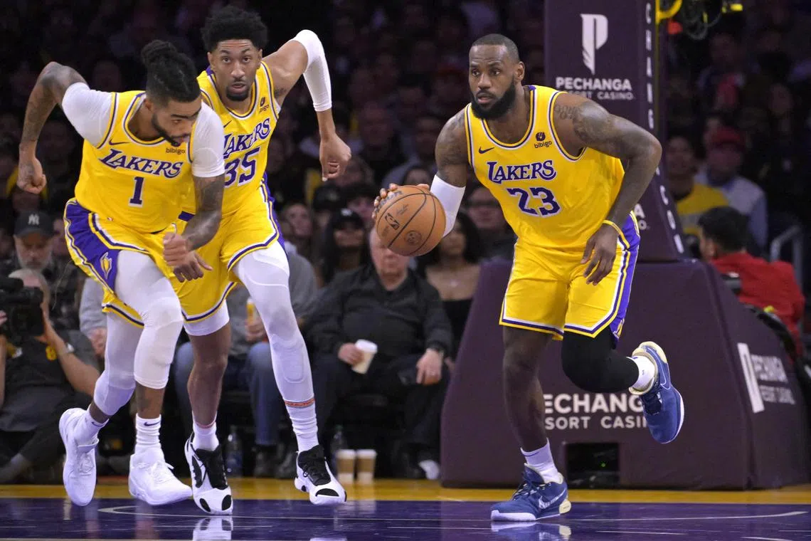 Los Angeles Lakers guard D'Angelo Russell and forward Christian Wood trail as forward LeBron James takes the ball down court in the first half against the Charlotte Hornets at Crypto.com Arena. 