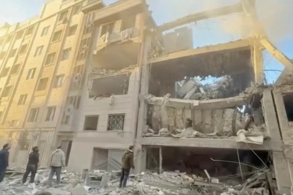 People stand near damaged buildings, amid the U.S.-Israeli conflict with Iran, in Tehran, Iran, in this still image obtained from a handout video released on April 1, 2026.    Iranian Red Crescent Society/Handout via REUTERS