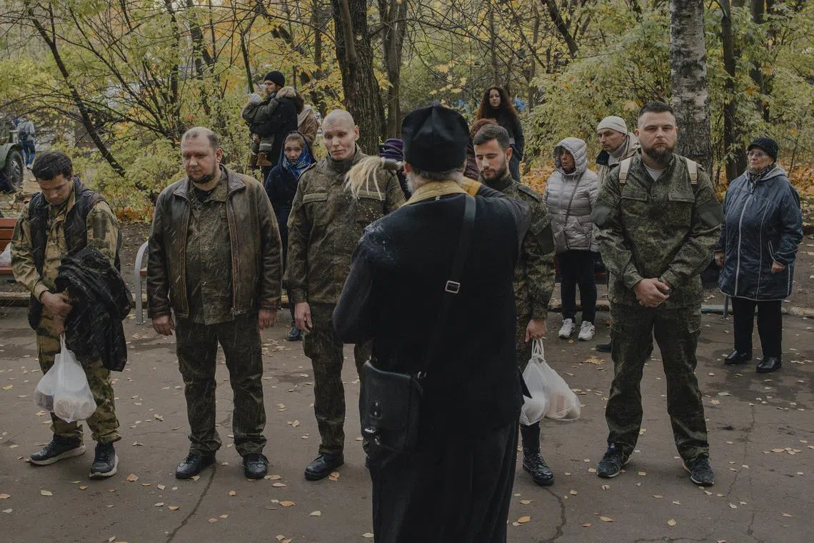 A Russian Orthodox priest performs a blessing for conscripted men in Moscow.