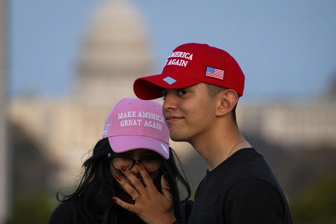 Trump supporters wearing Make America Great Again hats are seen with the US Capitol Building in the background, in Washington.