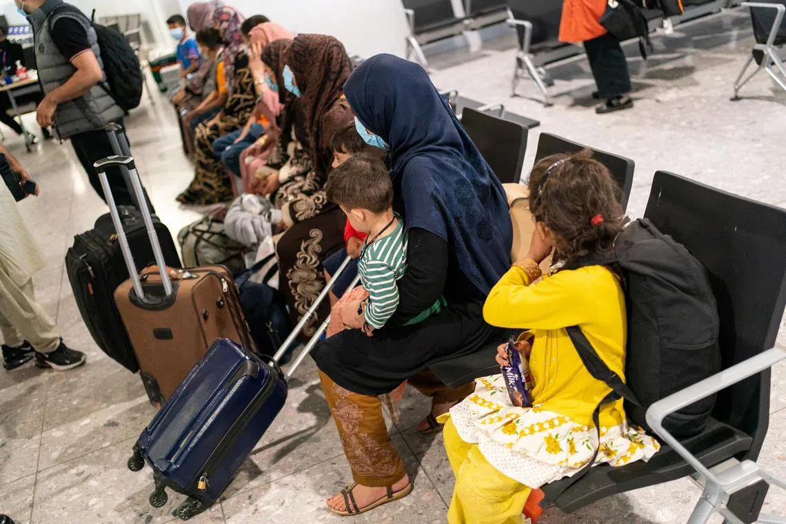 FILE PHOTO: Refugees from Afghanistan wait to be processed after arriving on an evacuation flight at Heathrow Airport, in London, Britain August 26, 2021. Dominic Lipinski/Pool via REUTERS/ File Photo