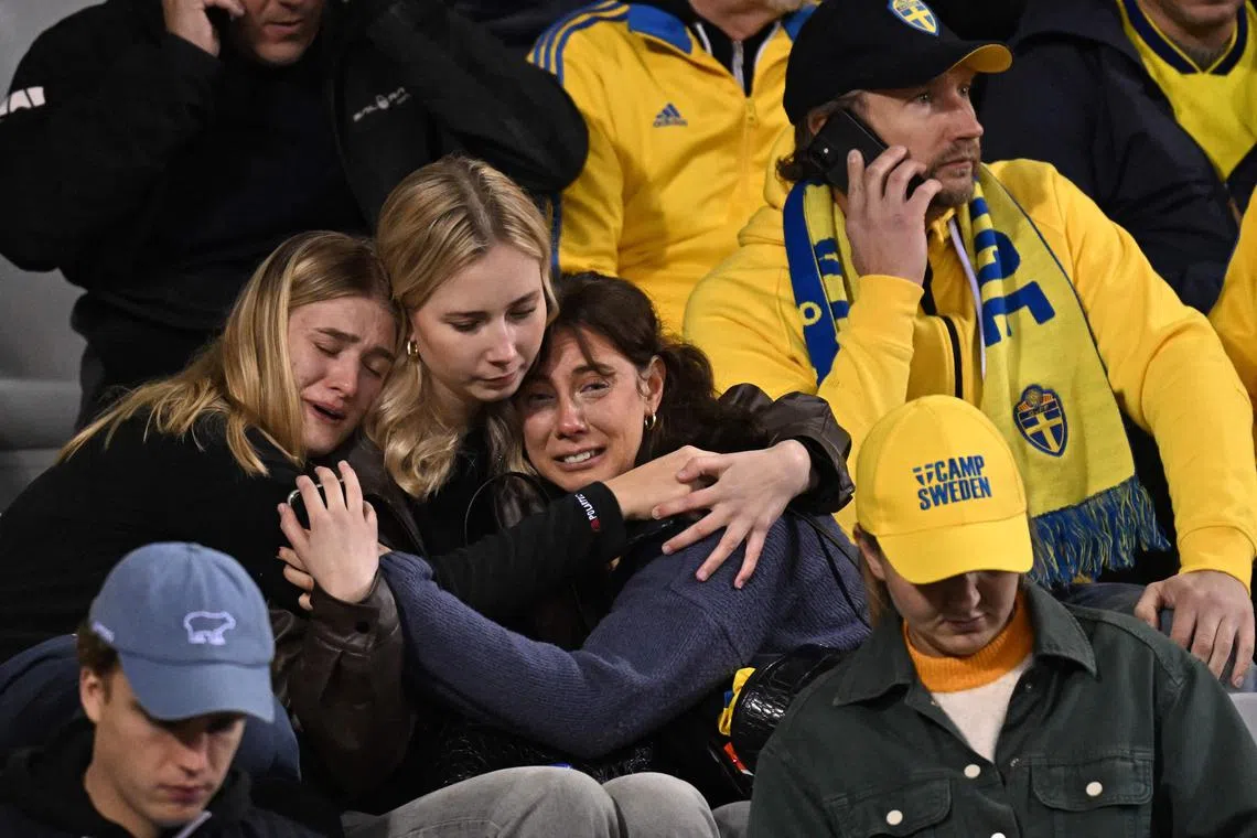 Swedish supporters react as the match is abandoned at halftime, due to the fatal shooting of two Swedes in Brussels.