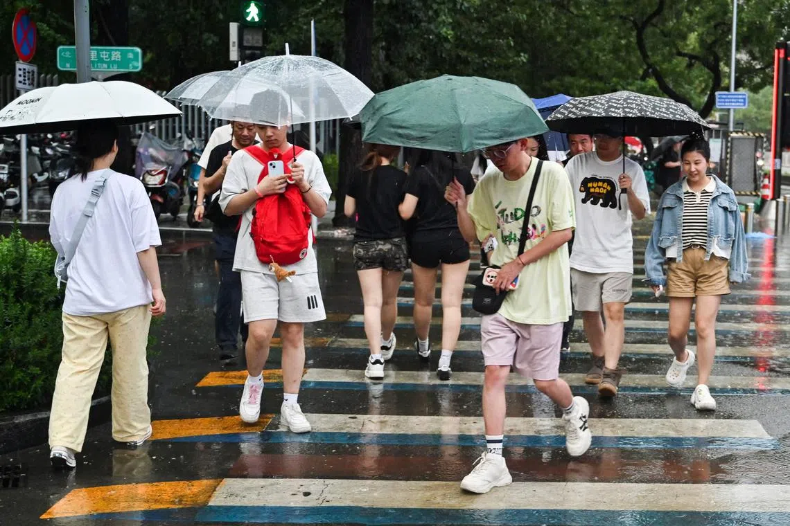 People use umbrellas to shelter from heavy rain in Beijing on July 12.