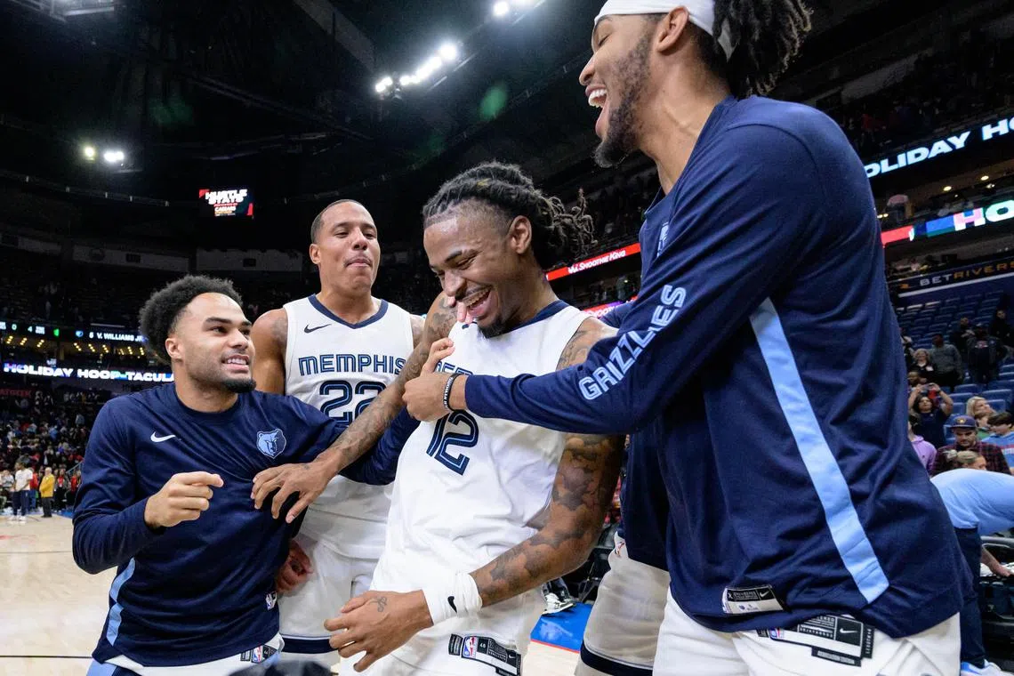 Memphis Grizzlies guard Ja Morant is mobbed by teammates after scoring the game-winning basket against the New Orleans Pelicans.