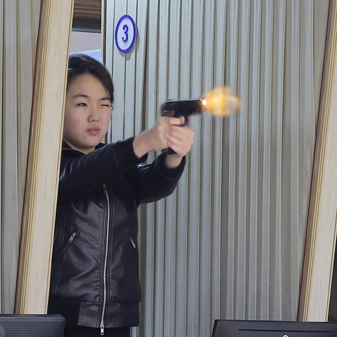 North Korean leader Kim Jong Un's daughter Kim Ju Ae (centre) test firing a new-type pistol during an inspection of a major munitions factory.
