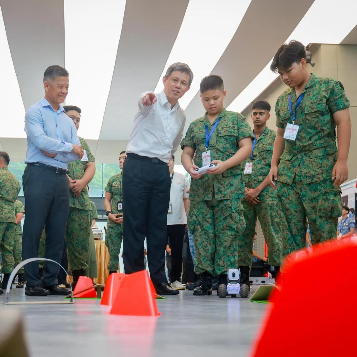 Minister for Defence Chan Chun Sing (centre) viewing land surveillance robots with NCC cadets from Peirce Secondary, on Aug 26.