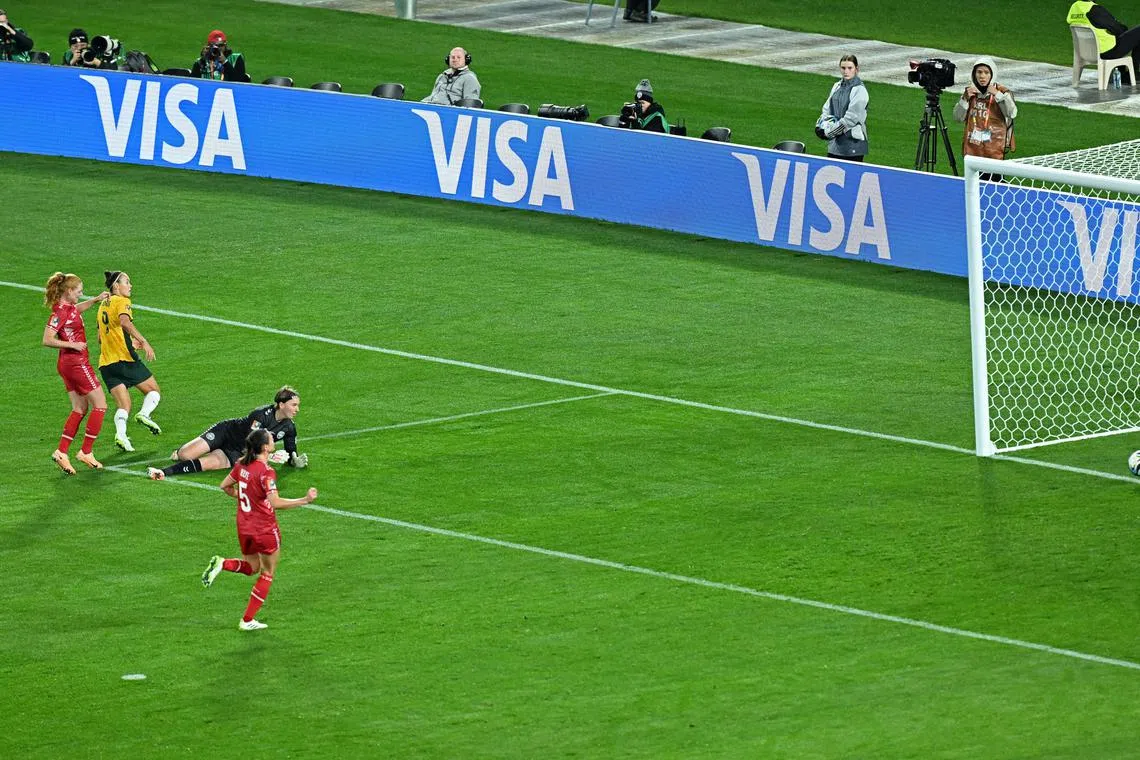 Australia's Caitlin Foord (in yellow) slotting the ball past Denmark goalkeeper Lene Christensen to give her side the lead. The Matildas scored another to win 2-0 on the night and progress to the Women's World Cup quarter-finals. 