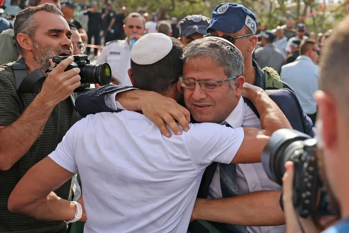 Israel's National Security Minister Itamar Ben-Gvir hugs a supporter as he arrives to the site of a reported attack in the Israeli settlement of Maale Adumim in the occupied West Bank, on August 1, 2023. A suspected Palestinian gunman opened fire on August 1 at a group of Israelis in an occupied West Bank settlement, wounding four before being "neutralised" by an off-duty border officer, police said. (Photo by AHMAD GHARABLI / AFP)