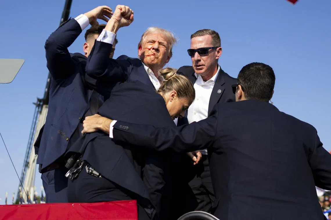 A bloodied Donald Trump is surrounded by Secret Service agents before being rushed off the stage at a campaign rally in Butler, Pennsylvania, on July 13, 2024.