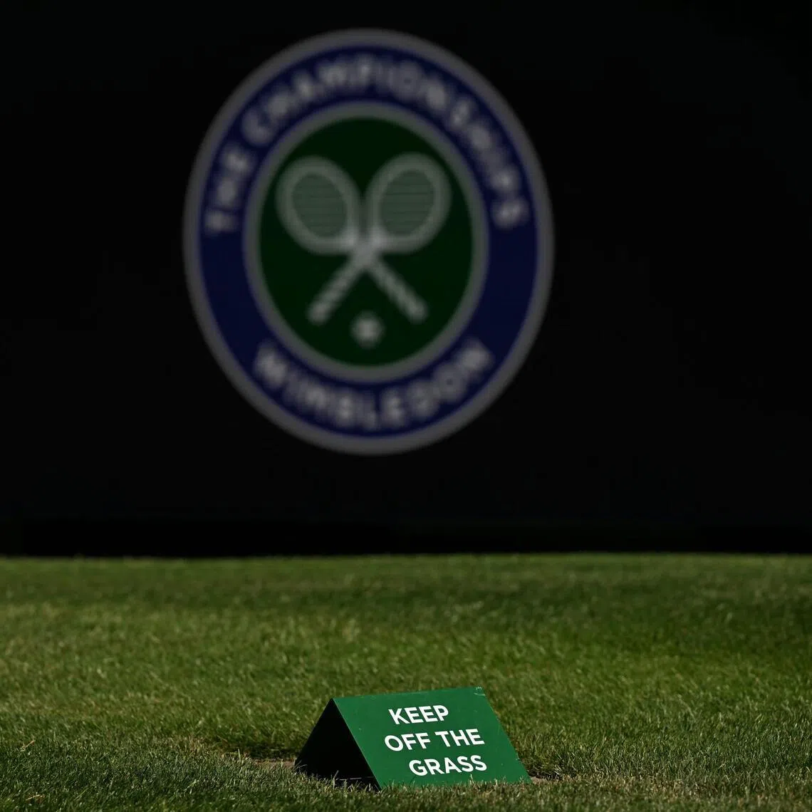 A keep of the grass sign is pictured on a court at The All England Lawn Tennis and Croquet Club in Wimbledon, southwest London, on June 24, 2026, ahead of the 2026 Wimbledon Championships. (Photo by Glyn KIRK / AFP) / RESTRICTED TO EDITORIAL USE