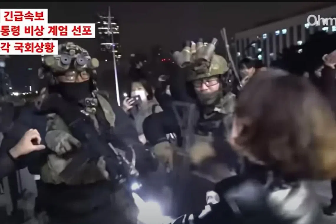 A woman, identified by South Korean news sites as Democratic Party of Korea member Ahn Gwi Ryeong, is seen tussling with soldiers outside the National Assembly in Seoul on Dec 4, 2024.