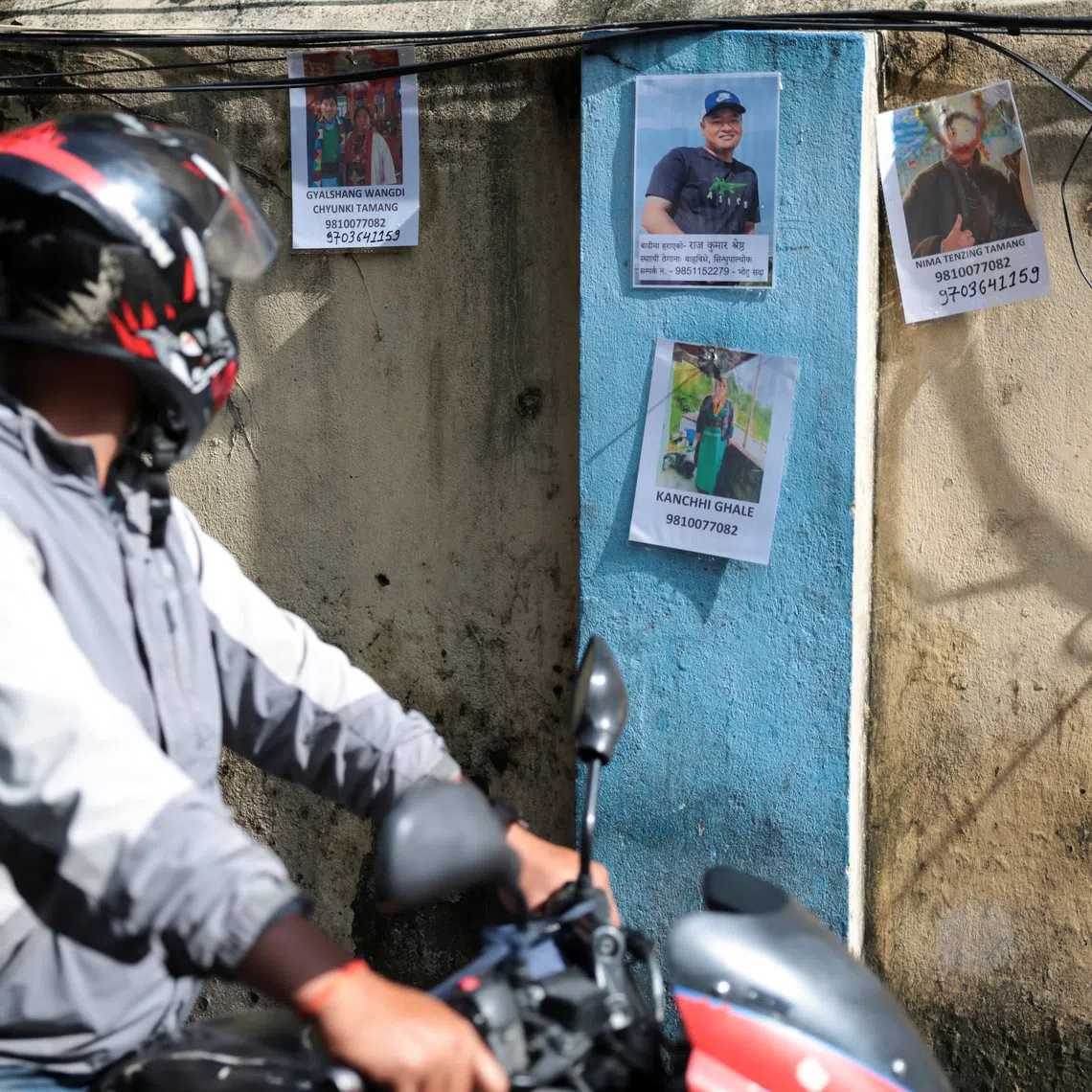 A man looks at pictures of missing people following flash floods and a mudslide, at the Trauma Center in Kathmandu, Nepal, August 28, 2026. REUTERS/Athit Perawongmetha