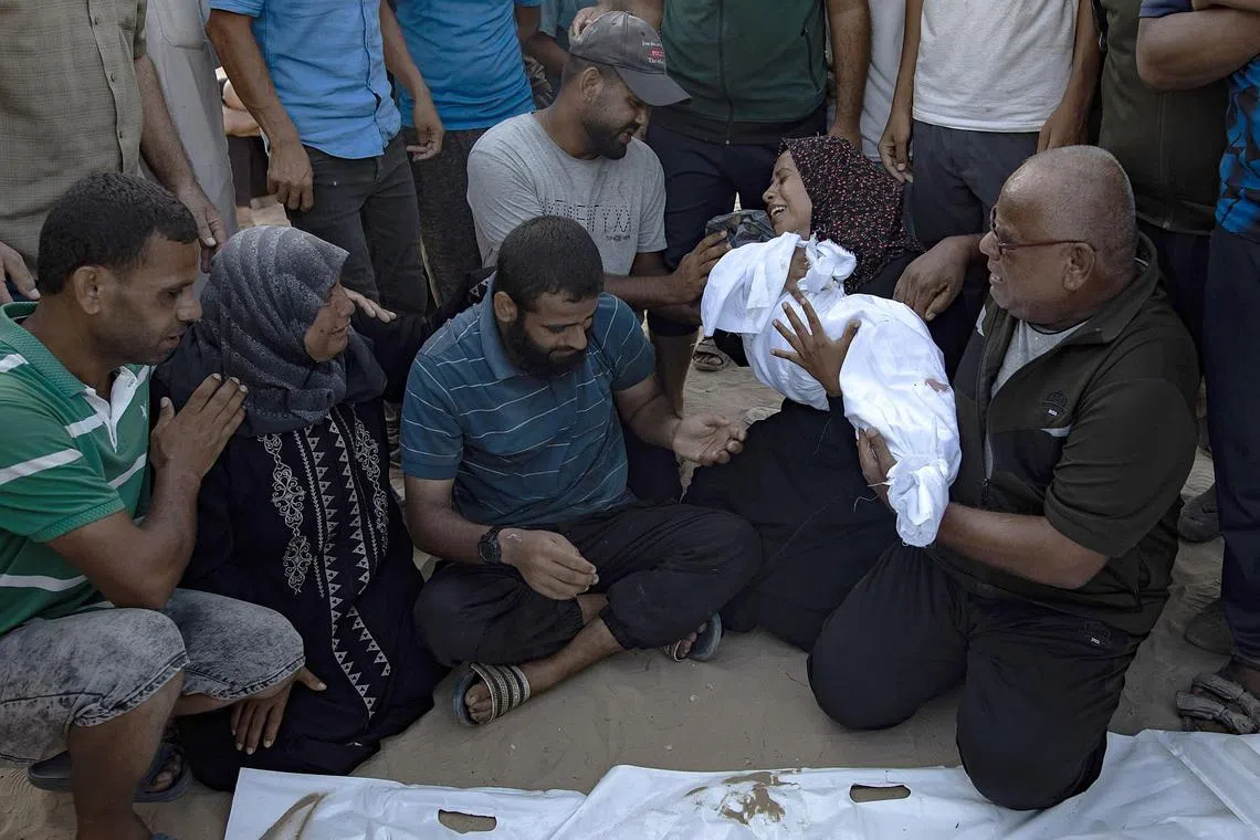 A Palestinian mother holds the body of her baby girl, who was killed in an Israeli air strike on the refugee camp of Khan Younis, on July 28, 2024.