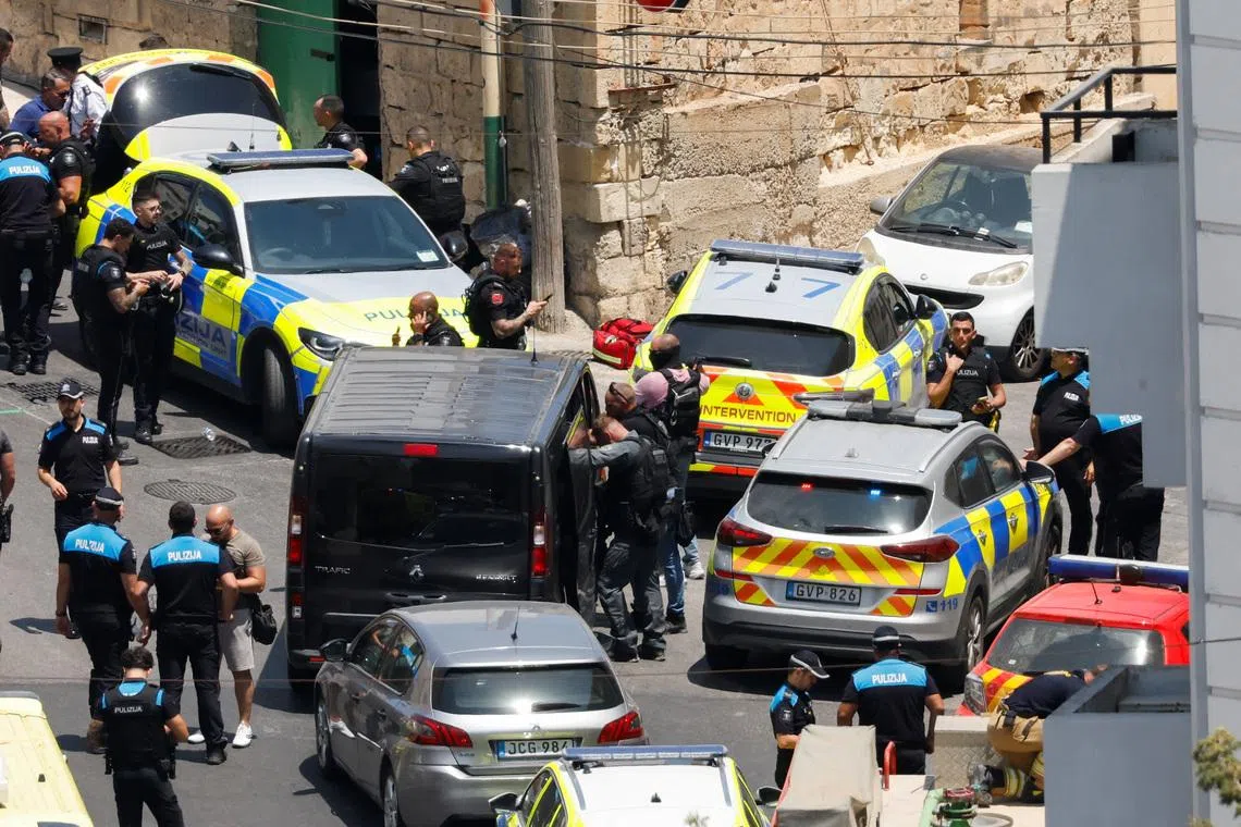 Armed police officers gather outside a building after an operation to arrest a man who shot and injured two police officers in St Julian's, Malta, July 24, 2026. REUTERS/Darrin Zammit Lupi