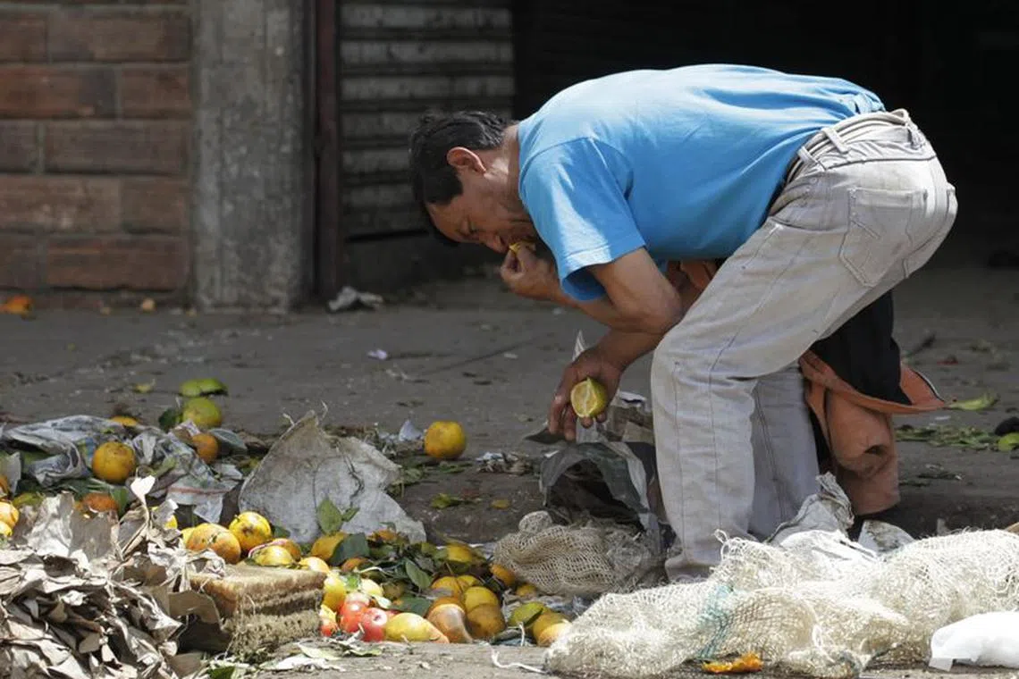 A man looks for leftover vegetables and fruits at a local market in Bogota March 7, 2012  REUTERS/John  Vizcaino/File Photo