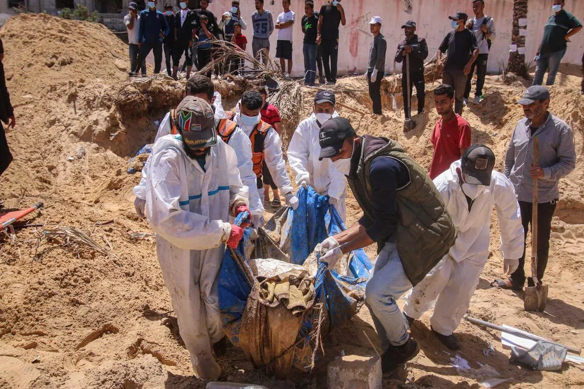 Palestinian health workers recover bodies from a mass grave at the Nasser Medical Hospital compound in Khan Younis on April 21.