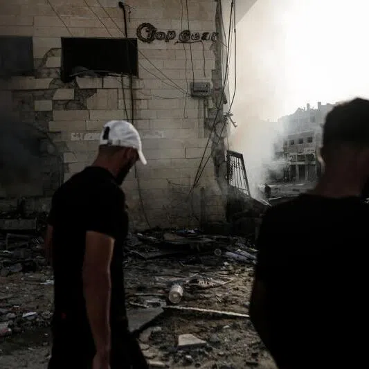 Palestinians inspect the debris on July 24 following an Israeli air strike in Gaza City.