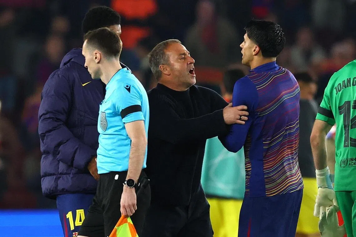 Barcelona coach Hansi Flick pushing away Joao Cancelo from the match officials after the 2-0 home Champions League quarter-final, first-leg defeat by Atletico Madrid at the Camp Nou on April 8, 2026.