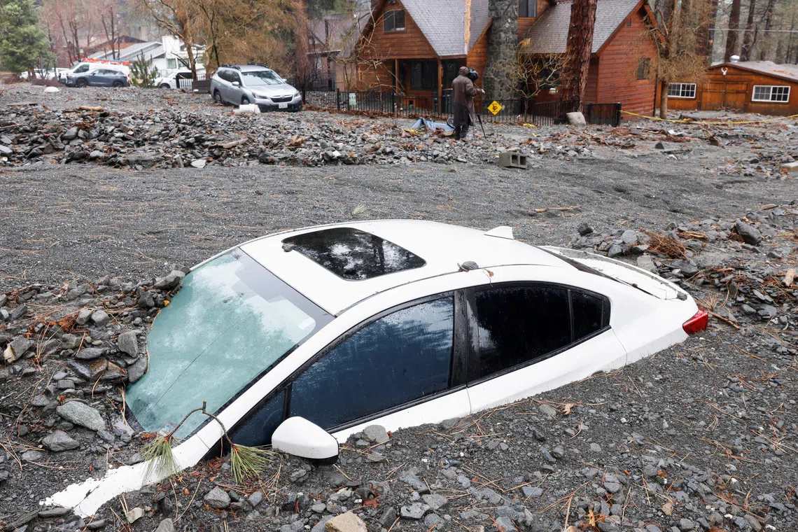 A car lies partially buried, as heavy rains fall due to an atmospheric river, in Wrightwood, California, U.S., December 26, 2025. REUTERS/Jill Connelly