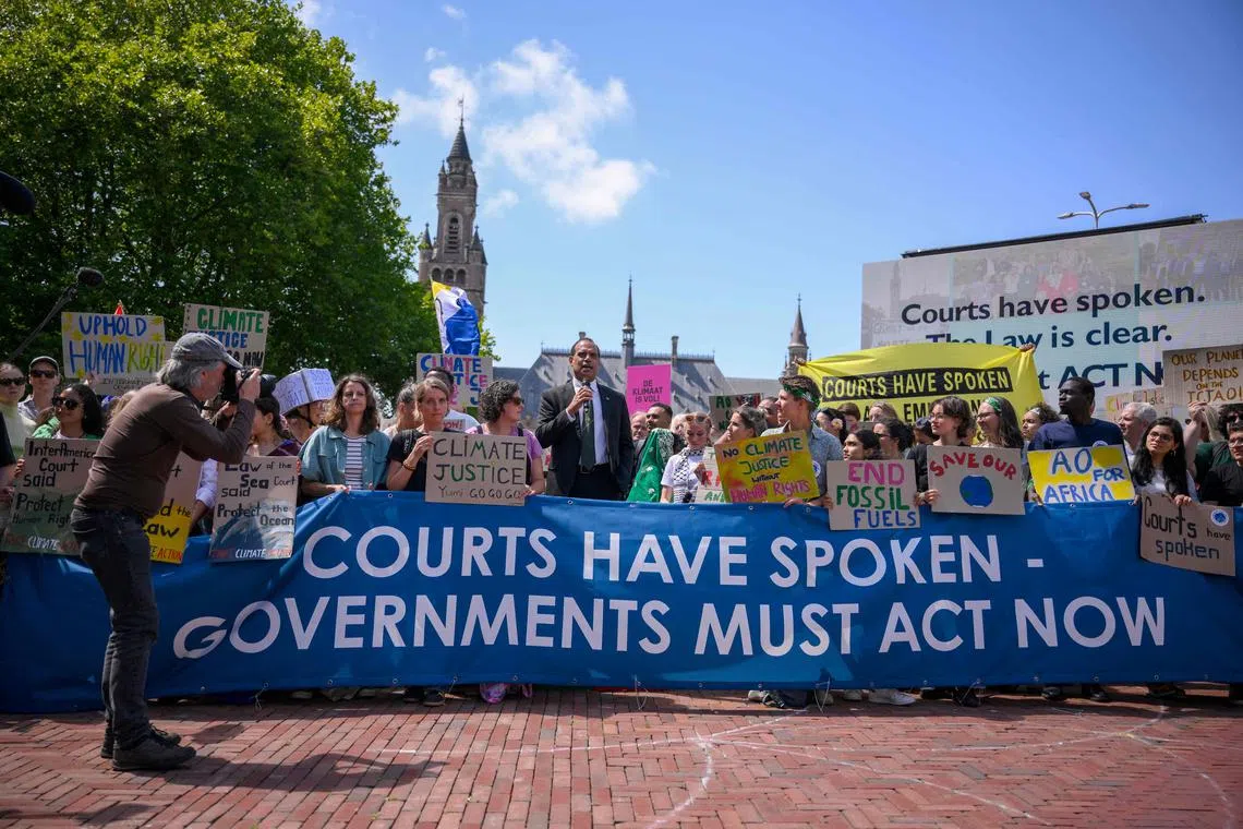 TOPSHOT - Vanuatu's Climate Change Minister Ralph Regenvanu (C) delivers a speech as he attends a demonstration ahead of the ICJ's reading of the advisory opinion in The Hague on July 23, 2025. 