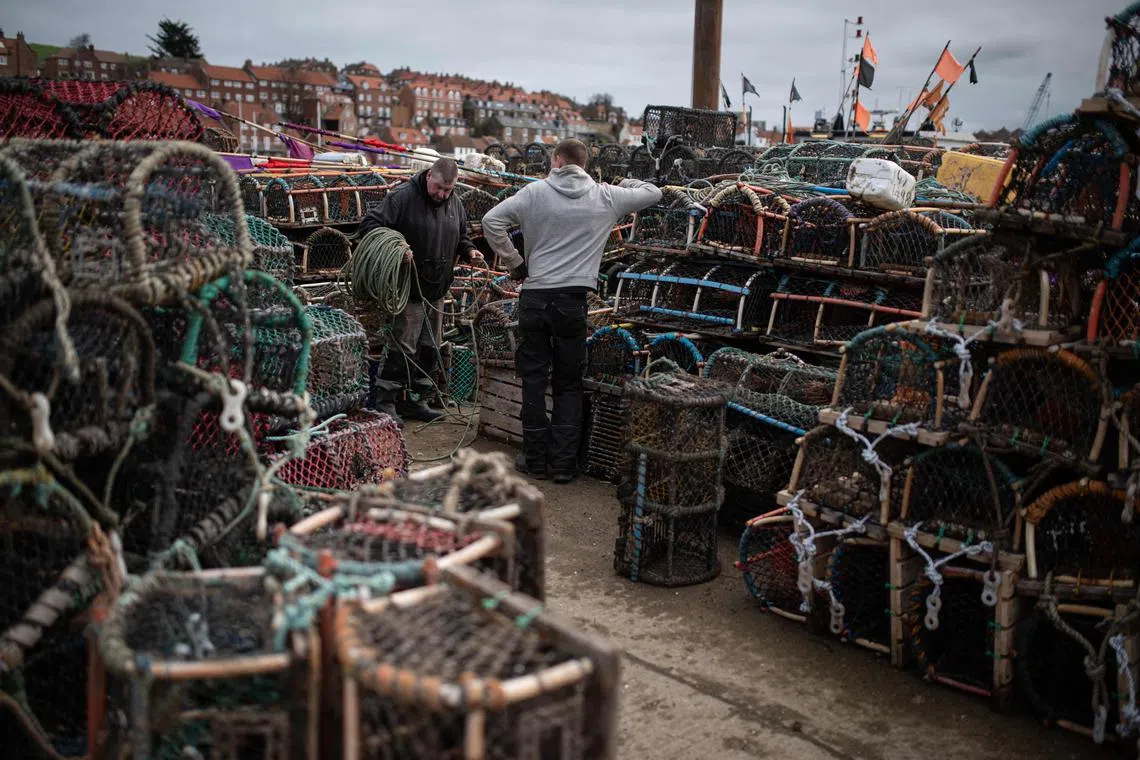 Fishers prepare their lobster pots before fishing in the North Sea, in Whitby, northern England, on March 2, 2023. 