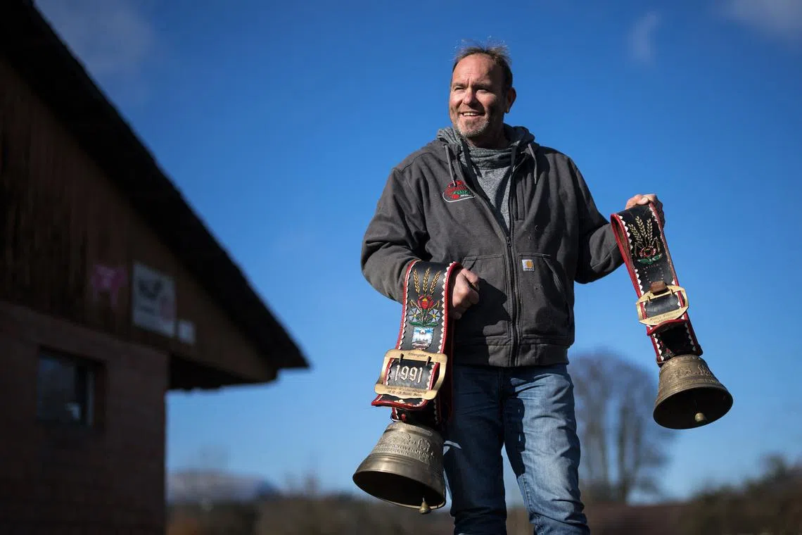 A farmer holds cow bells used during transhumance in the village of Aarwangen, Switzerland.