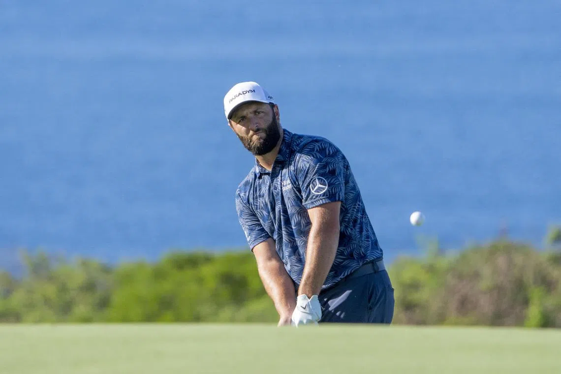 Jon Rahm hits his chip shot on the 14th hole during the first round of the Sentry Tournament of Champions.