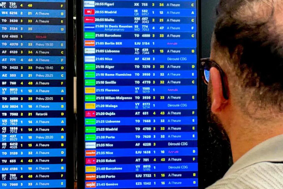 A traveller looks at a flights informations board during a breakdown in air traffic control systems at Paris-Orly airport in Orly, South of Paris, on May 18, 2025. Around 130 flights were cancelled on May 18, 2025 at Paris-Orly airport, affected by a breakdown in air traffic control systems, a spokesman for Aéroports de Paris (ADP) told AFP. (Photo by Aurore MESENGE / AFP)