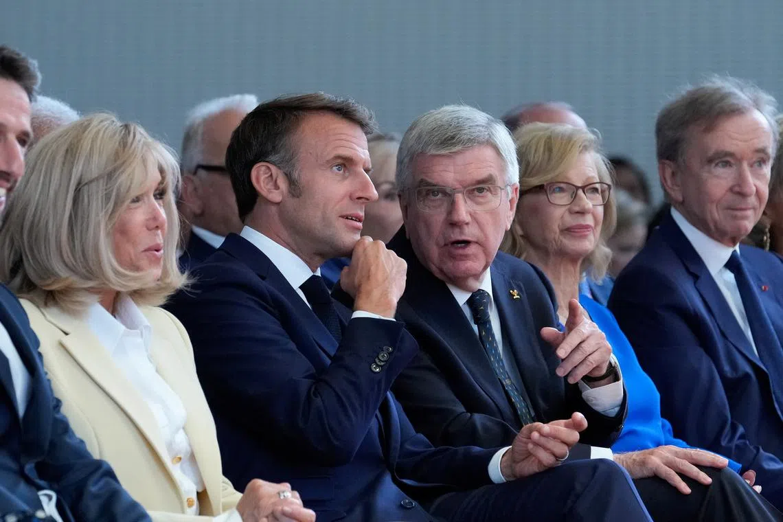 International Olympic Committee President Thomas Bach, French President Emmanuel Macron, his wife Brigitte Macron, and LVMH CEO Bernard Arnault attend the IOC Session Opening Ceremony at the Louis Vuitton Foundation ahead of the 2024 Summer Olympics, July 22, 2024, in Paris, France. Thibault Camus/Pool via REUTERS