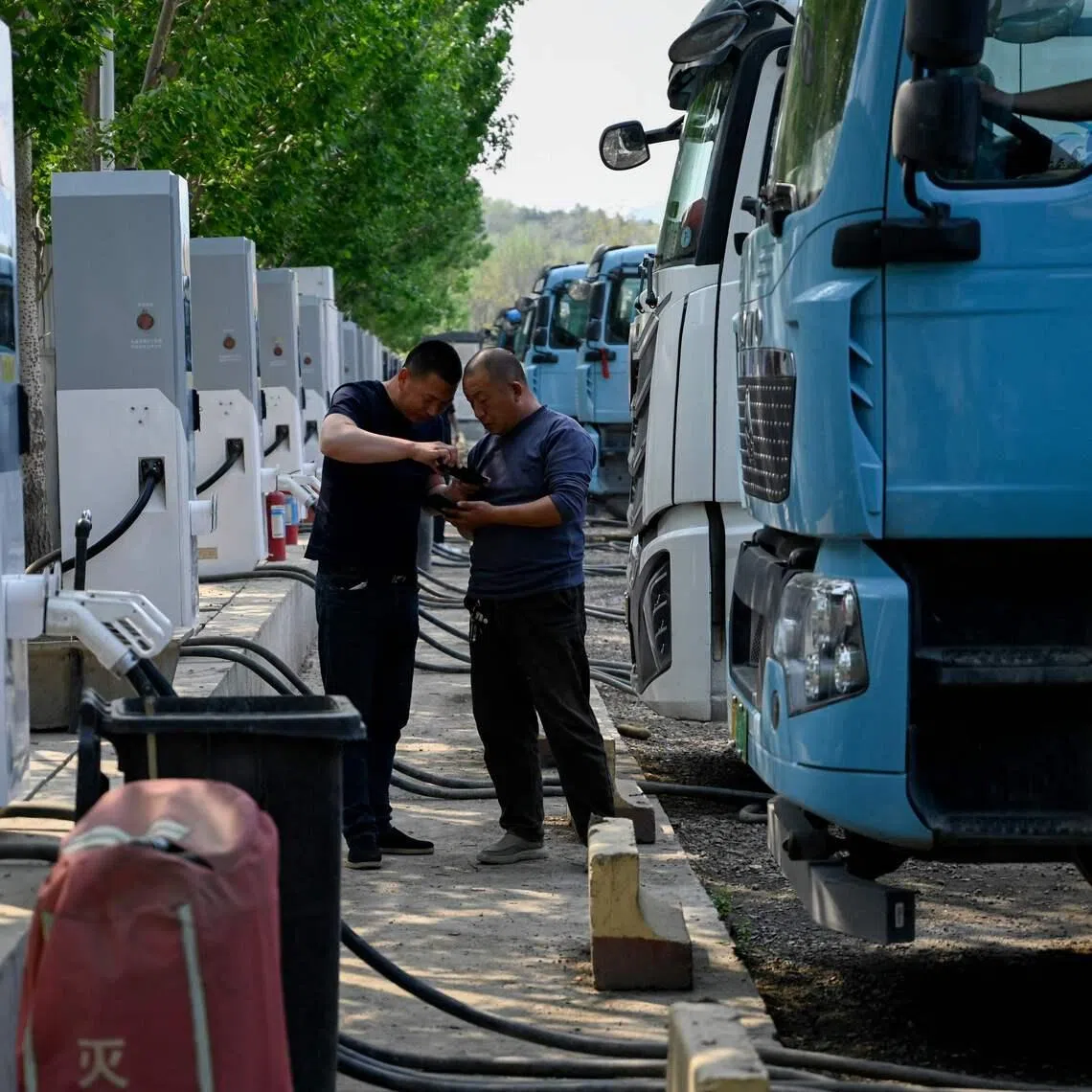 Electric truck drivers at a charging station in Beijing on April 23. Adoption of alternatives to diesel trucks has noticeably accelerated in recent years.