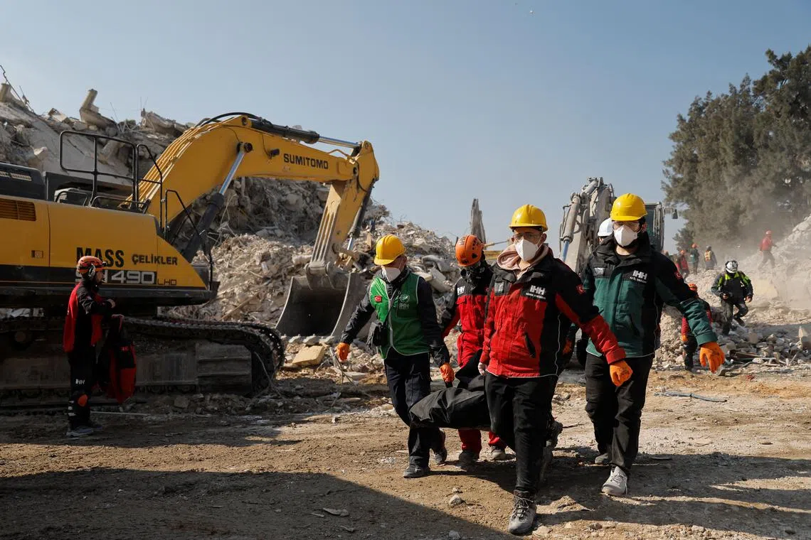 Rescuers carry the body of a victim from the earthquake rubble in  Antakya, Turkey, on Feb 18, 2023.