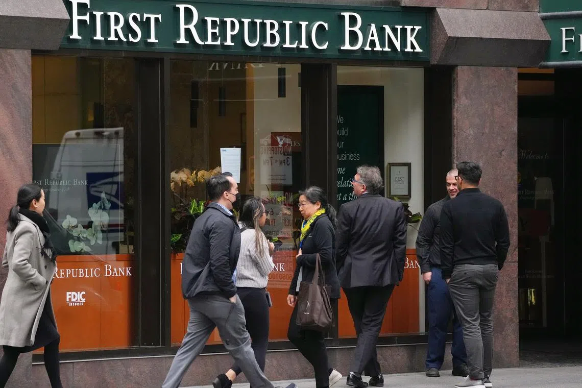 People pause to read and photograph a press release from the FDIC taped in the window at the headquarters of First Republic Bank in San Francisco, May 1, 2023. First Republic had about $200 billion in assets when it collapsed. (Jim Wilson/The New York Times)